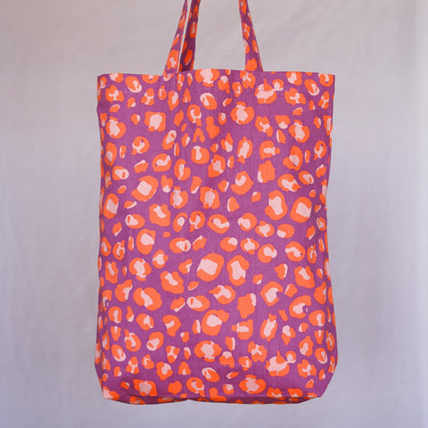 Tasche aus Baumwolle von Kleine Fete im Leomuster. Die Farben des Shoppers sind lila neonorange und lachs